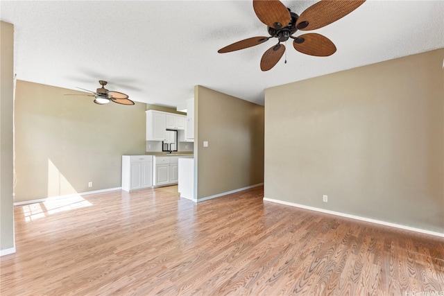 94-1336 Kulewa Loop Unit 5D, Waipahu, HI 96797 - unfurnished living room featuring ceiling fan, light wood-style floors, and baseboards
