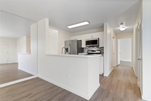 91-225 Hanapouli Cir Unit 33F, Ewa Beach, HI 96706 - kitchen featuring stainless steel appliances, light wood-type flooring, tasteful backsplash, and white cabinets
