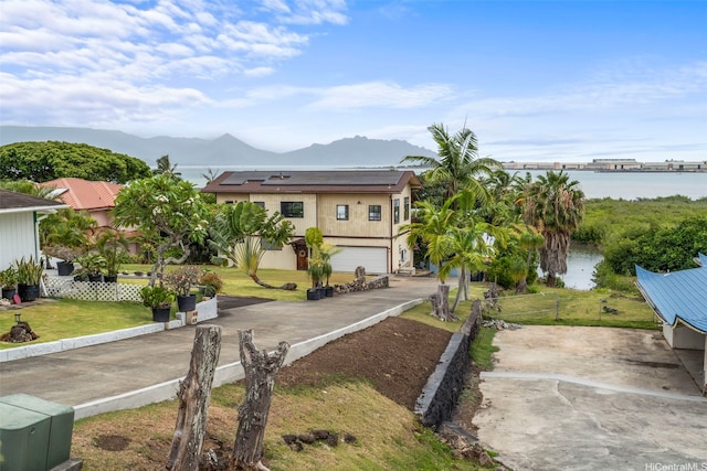 44-279 Kaneohe Bay Dr Unit B, Kaneohe, HI 96744 - view of front of property featuring roof mounted solar panels, a water and mountain view, a front yard, and an attached garage