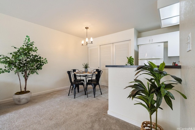 492 Mananai Pl Unit 13E, Honolulu, HI 96818 - dining area featuring light colored carpet, a chandelier, and baseboards