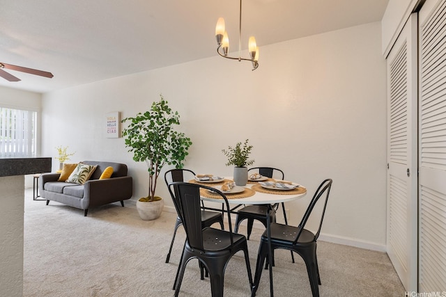 492 Mananai Pl Unit 13E, Honolulu, HI 96818 - dining space featuring a ceiling fan, light carpet, a chandelier, and baseboards