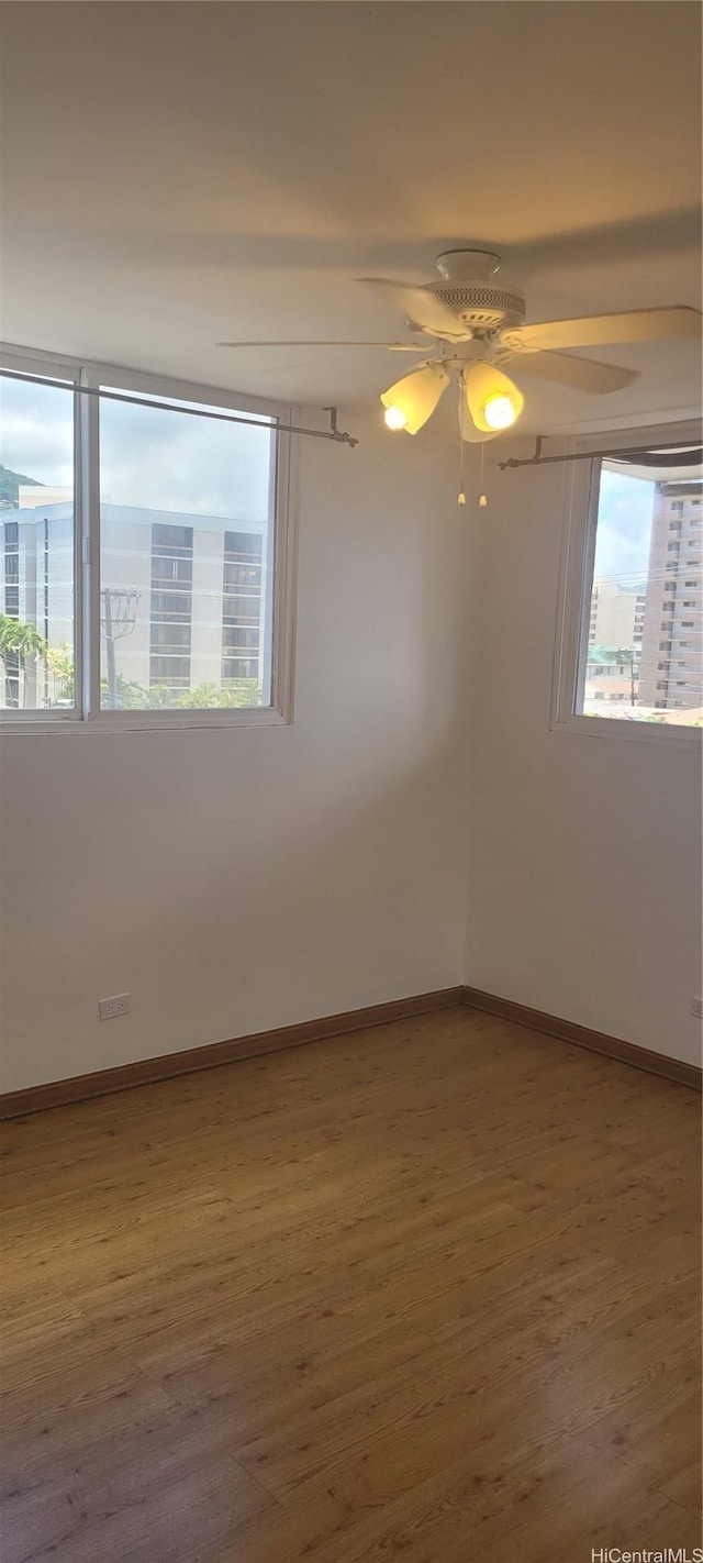1402 Piikoi St Unit 502, Honolulu, HI 96822 - unfurnished room featuring wood finished floors, baseboards, and ceiling fan