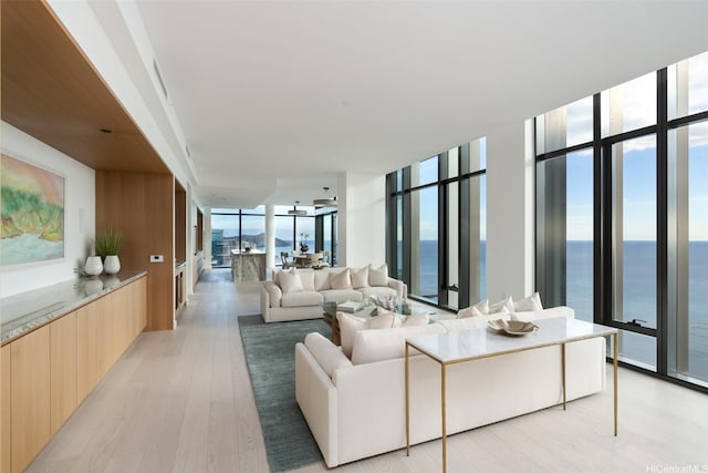 1100 Ala Moana Blvd Unit 4000/4001, Honolulu, HI 96814 - living room featuring floor to ceiling windows, a water view, and light wood-style floors