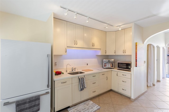 1020 Green St Unit 303, Honolulu, HI 96822 - kitchen featuring white refrigerator, stainless steel microwave, arched walkways, light countertops, and light tile patterned floors