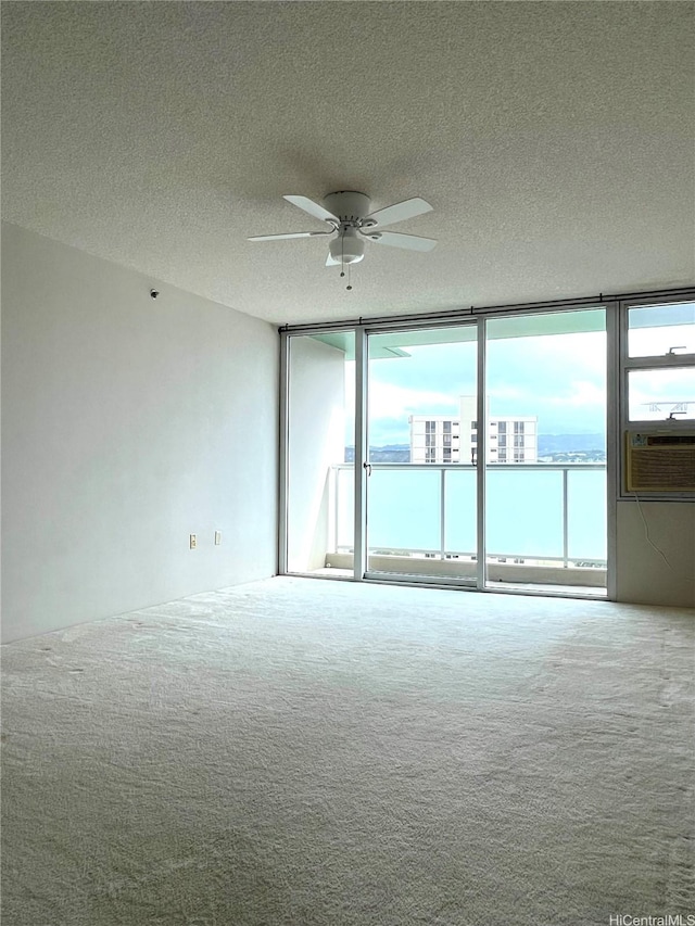 3009 Ala Makahala Pl Unit 1815, Honolulu, HI 96818 - unfurnished room featuring carpet flooring, cooling unit, a ceiling fan, a textured ceiling, and expansive windows