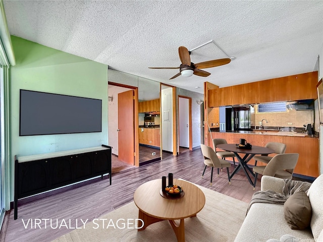 955 Ala Lilikoi St Unit 305, Honolulu, HI 96818 - living area with wood finished floors, a ceiling fan, and a textured ceiling