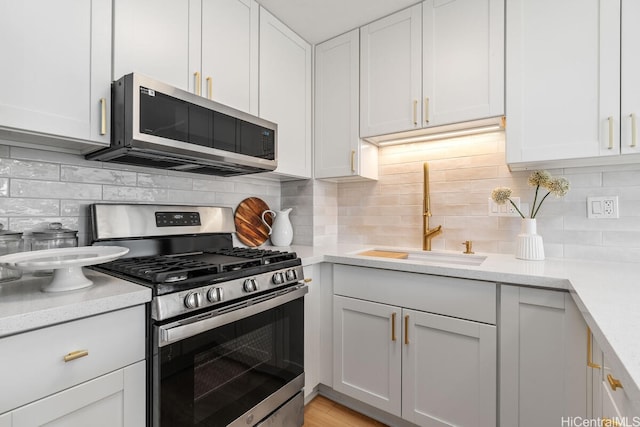 53-549 Kamehameha Hwy Unit 402, Hauula, HI 96717 - kitchen featuring appliances with stainless steel finishes, light countertops, tasteful backsplash, and white cabinets