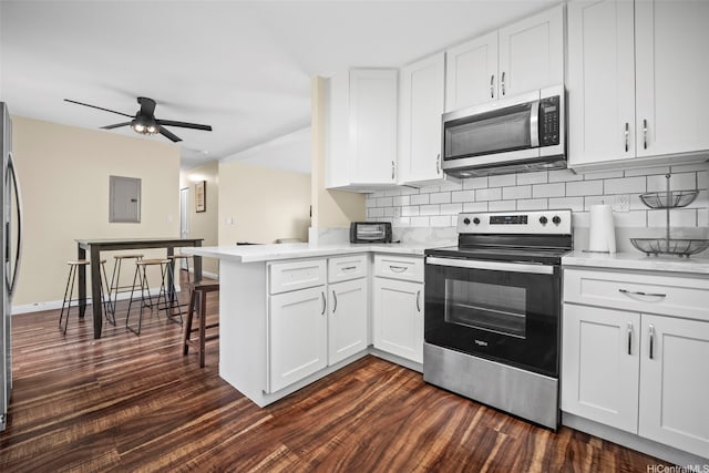 53-388 Kamehameha Hwy, Hauula, HI 96717 - kitchen featuring stainless steel appliances, dark wood-type flooring, a peninsula, white cabinetry, and backsplash