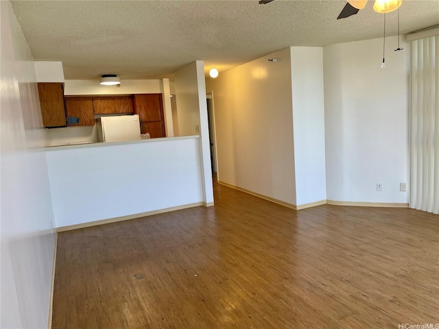930 Kaheka St Unit 1703, Honolulu, HI 96814 - unfurnished living room featuring a textured ceiling, wood finished floors, and a ceiling fan