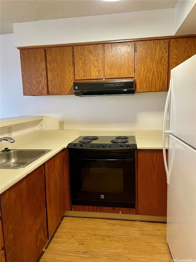 930 Kaheka St Unit 1703, Honolulu, HI 96814 - kitchen featuring freestanding refrigerator, black range with electric cooktop, range hood, light countertops, and brown cabinetry
