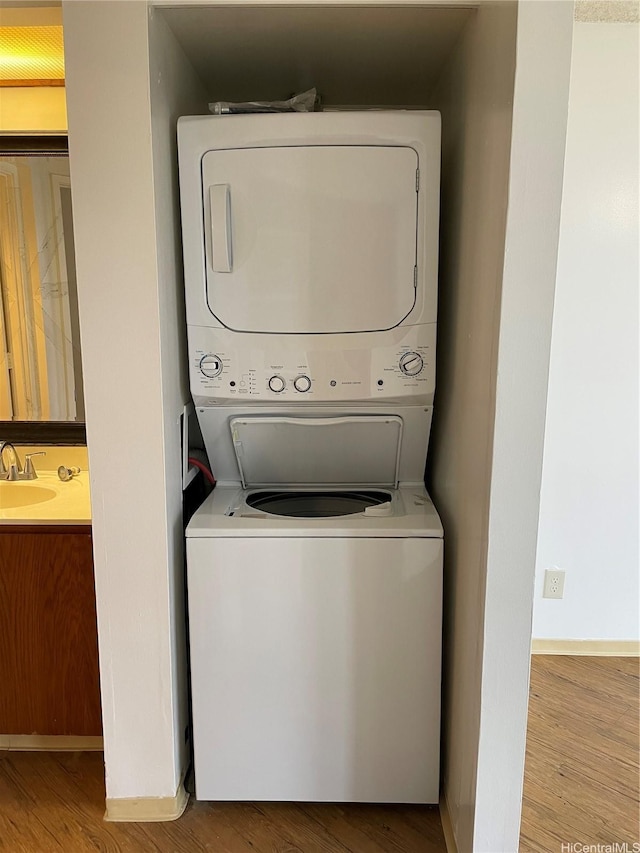 930 Kaheka St Unit 1703, Honolulu, HI 96814 - washroom featuring stacked washer / drying machine and wood finished floors