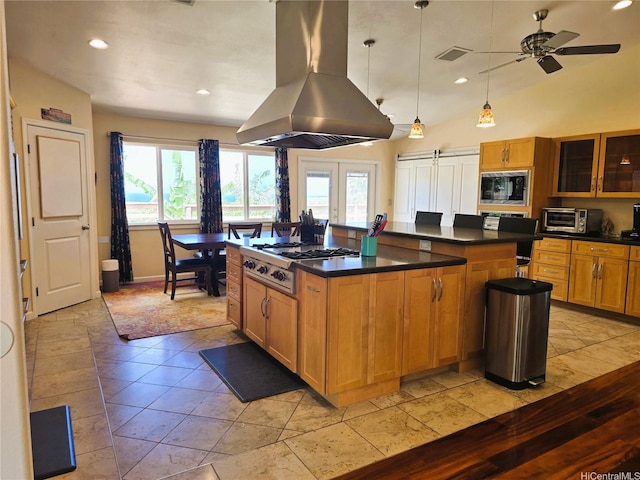 92-882 Wainohia St, Kapolei, HI 96707 - kitchen featuring island exhaust hood, stainless steel gas cooktop, black microwave, dark countertops, and healthy amount of natural light