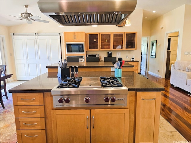 92-882 Wainohia St, Kapolei, HI 96707 - kitchen featuring exhaust hood, built in microwave, stainless steel gas stovetop, a kitchen island, and glass insert cabinets