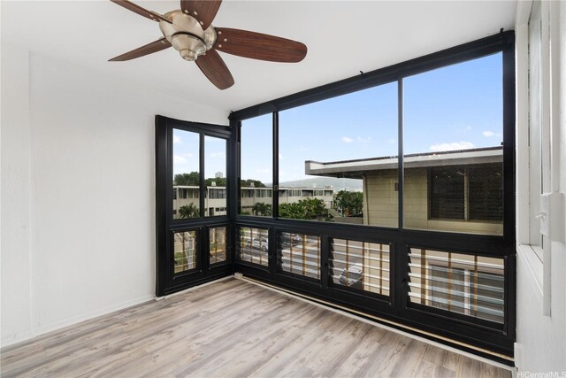 3071 Pualei Cir Unit 201, Honolulu, HI 96815 - unfurnished room featuring wood finished floors, ceiling fan, a wall of windows, and baseboards