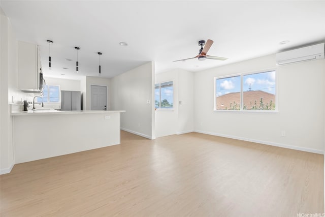 87-1474 Akowai Rd, Waianae, HI 96792 - unfurnished living room with a wall mounted air conditioner, light wood finished floors, ceiling fan, and recessed lighting