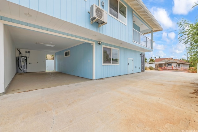 87-1474 Akowai Rd, Waianae, HI 96792 - view of side of home featuring water heater, concrete driveway, a carport, and a balcony
