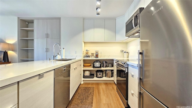 1910 Ala Moana Blvd Unit 32E, Honolulu, HI 96815 - kitchen with appliances with stainless steel finishes, modern cabinets, light wood-style floors, light countertops, and white cabinets