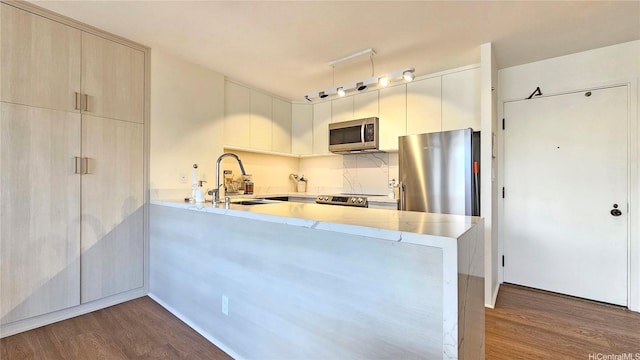 1910 Ala Moana Blvd Unit 32E, Honolulu, HI 96815 - kitchen featuring stainless steel appliances, dark wood-style floors, a peninsula, and modern cabinets