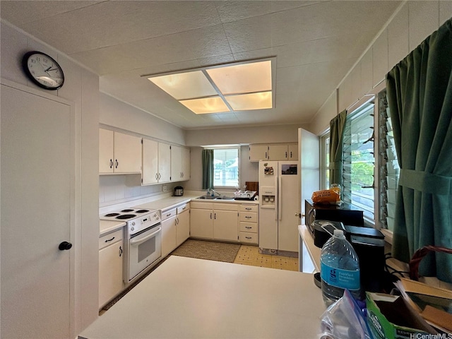 661 Iliaina St, Kailua, HI 96734 - kitchen featuring white appliances, light countertops, white cabinets, a sink, and light floors