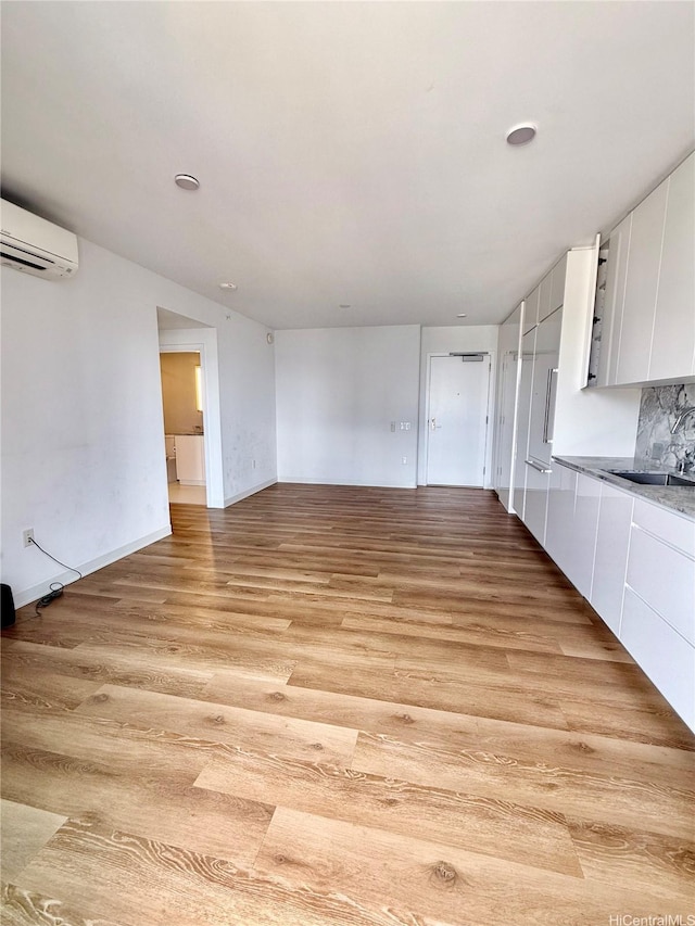 987 Queen St Unit 2403, Honolulu, HI 96814 - unfurnished room with an AC wall unit and light wood-style flooring