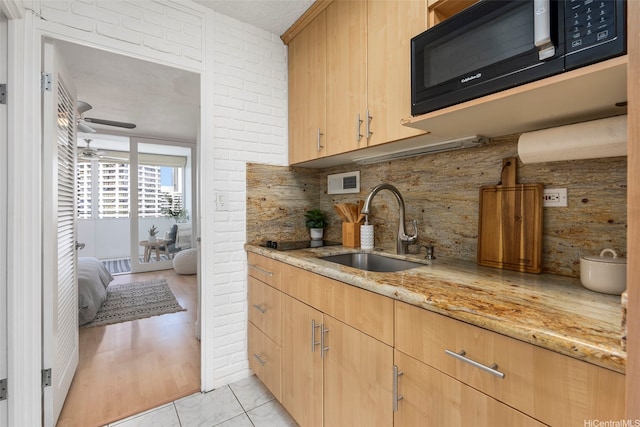 425 Ena Rd Unit Ph3B, Honolulu, HI 96815 - kitchen featuring black microwave, a sink, tasteful backsplash, light stone countertops, and ceiling fan