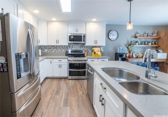 87-107 Kulaaupuni St Unit 2, Waianae, HI 96792 - kitchen with appliances with stainless steel finishes, white cabinets, light wood-style flooring, pendant lighting, and decorative backsplash