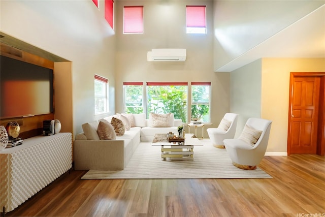 87-107 Kulaaupuni St Unit 2, Waianae, HI 96792 - living area with a wall mounted air conditioner, a towering ceiling, healthy amount of natural light, and wood finished floors