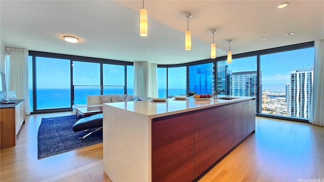 1108 Auahi St Unit 3201, Honolulu, HI 96814 - kitchen with modern cabinets, light wood-type flooring, floor to ceiling windows, decorative light fixtures, and light countertops