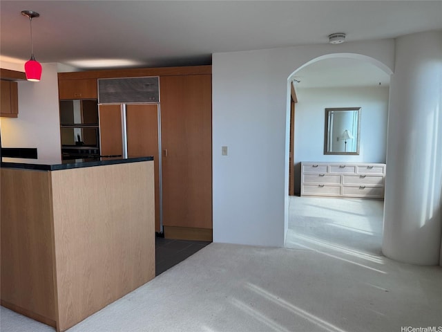 1330 Ala Moana Blvd Unit 2105, Honolulu, HI 96814 - kitchen featuring arched walkways, paneled built in fridge, brown cabinetry, hanging light fixtures, and carpet floors