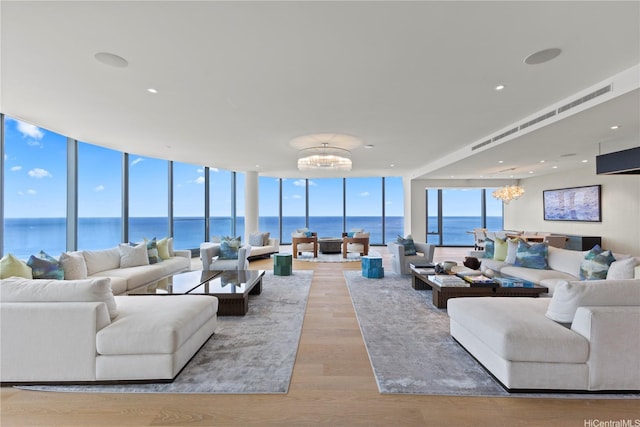 1108 Auahi St Unit 3800, Honolulu, HI 96814 - living area featuring a chandelier, a wall of windows, a water view, and light wood-type flooring