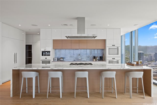 1108 Auahi St Unit 3800, Honolulu, HI 96814 - kitchen with modern cabinets, double oven, island range hood, and white cabinets