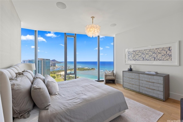 1108 Auahi St Unit 3800, Honolulu, HI 96814 - bedroom with a chandelier, multiple windows, wood finished floors, a water view, and expansive windows