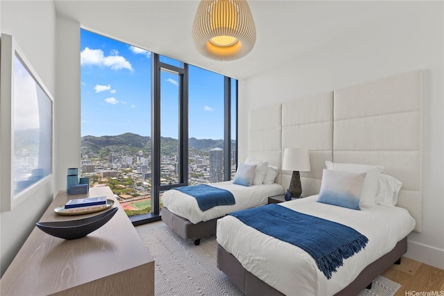 1108 Auahi St Unit 3800, Honolulu, HI 96814 - bedroom featuring a mountain view, a wall of windows, wood finished floors, and a view of city