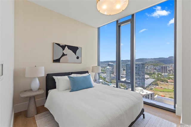 1108 Auahi St Unit 3800, Honolulu, HI 96814 - bedroom featuring a wall of windows, a city view, light wood finished floors, and a mountain view
