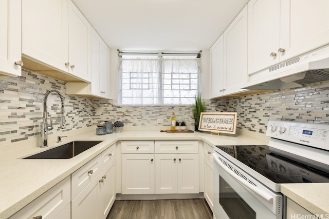 469 Ena Rd Unit 2004, Honolulu, HI 96815 - kitchen with white electric stove, a sink, under cabinet range hood, light countertops, and white cabinetry