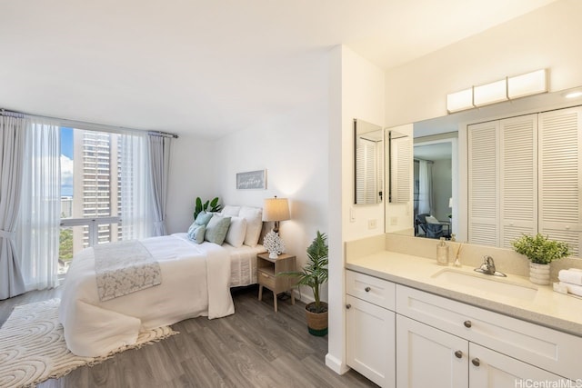 469 Ena Rd Unit 2004, Honolulu, HI 96815 - bedroom with a sink, wood finished floors, and connected bathroom