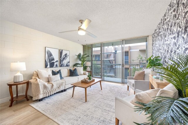 906 Lehua Ave Unit A306, Pearl City, HI 96782 - living area with expansive windows, wood finished floors, a textured ceiling, concrete block wall, and a ceiling fan