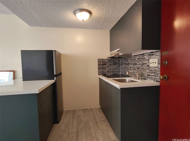 1560 Kanunu St Unit 1316, Honolulu, HI 96814 - kitchen featuring a sink, freestanding refrigerator, modern cabinets, light wood finished floors, and decorative backsplash
