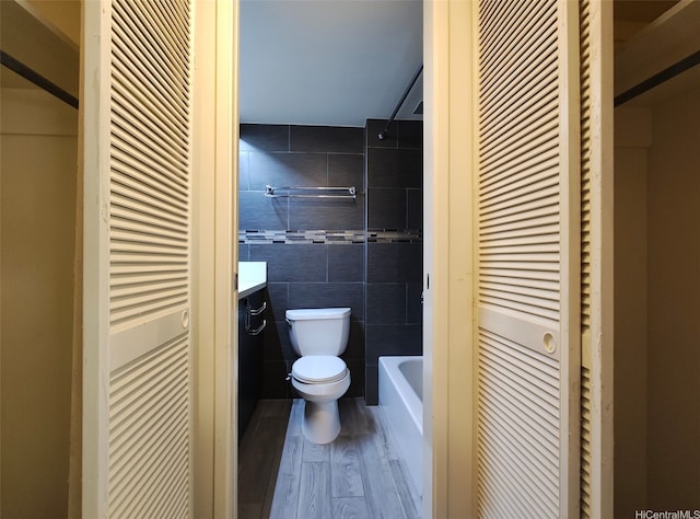1560 Kanunu St Unit 1316, Honolulu, HI 96814 - full bathroom featuring toilet, tile walls, a closet, vanity, and wood finished floors