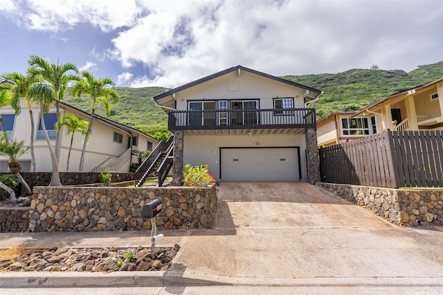 1305 Lunalilo Home Rd, Honolulu, HI 96825 - view of front facade with stairway, concrete driveway, a mountain view, and an attached garage