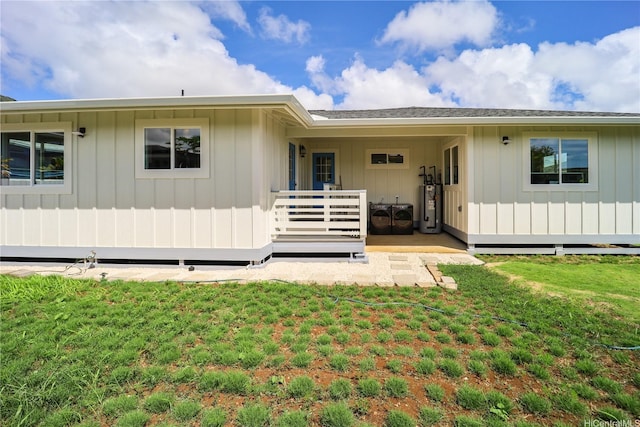 45-420 Pua Makahala St, Kaneohe, HI 96744 - back of property featuring water heater, a yard, a deck, and board and batten siding