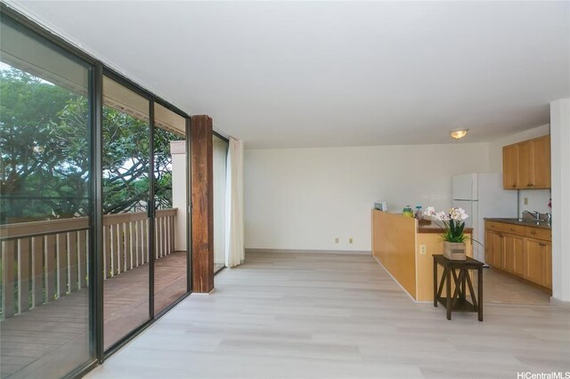 84-757 Kiana Pl Unit 6/21A, Waianae, HI 96792 - kitchen with floor to ceiling windows, light wood-style floors, freestanding refrigerator, dark countertops, and brown cabinets