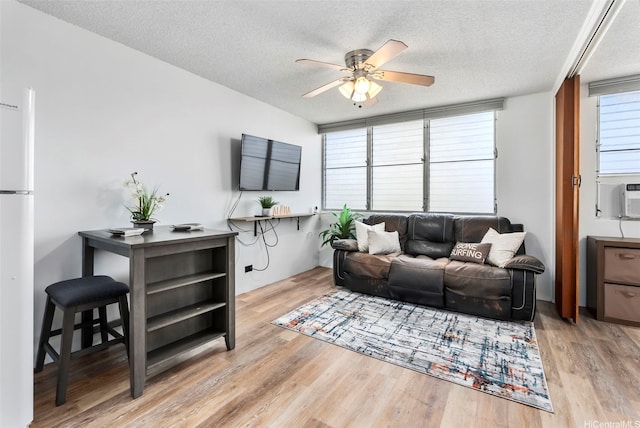 909 Kahuna Ln Unit 305, Honolulu, HI 96826 - living room featuring a textured ceiling, ceiling fan, light wood finished floors, and cooling unit