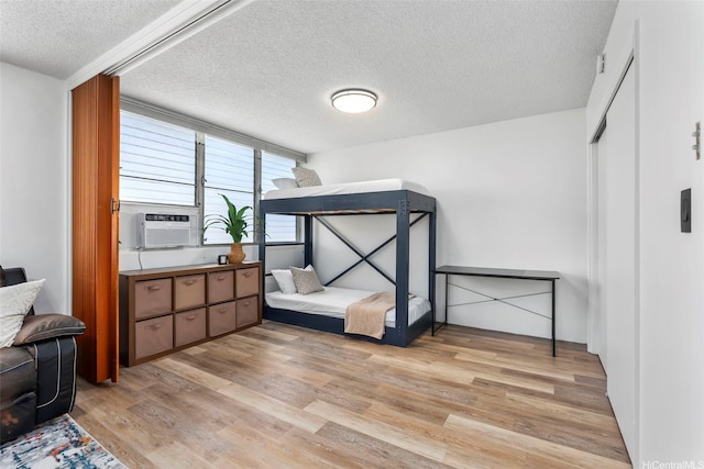 909 Kahuna Ln Unit 305, Honolulu, HI 96826 - bedroom featuring a textured ceiling, light wood-type flooring, cooling unit, and a closet
