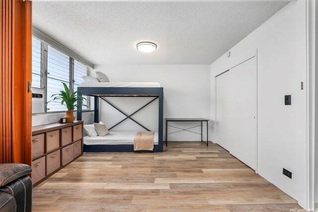 909 Kahuna Ln Unit 305, Honolulu, HI 96826 - unfurnished bedroom with light wood finished floors, a textured ceiling, and a closet