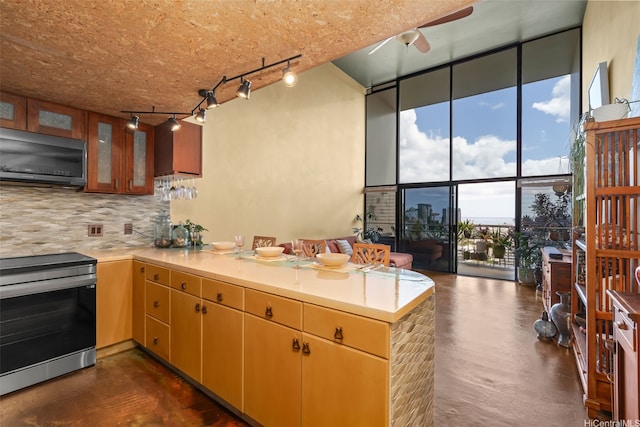 666 Prospect St Unit I502, Honolulu, HI 96813 - kitchen featuring stainless steel range with electric stovetop, rail lighting, concrete floors, backsplash, and floor to ceiling windows