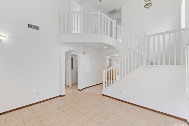 91-1022 Kaikauhaa St, Ewa Beach, HI 96706 - unfurnished living room featuring arched walkways, a towering ceiling, baseboards, and stairway