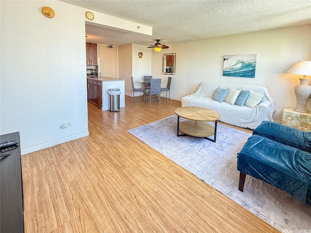 445 Seaside Ave Unit 1120, Honolulu, HI 96815 - living room with a ceiling fan, light wood-type flooring, a textured ceiling, and baseboards