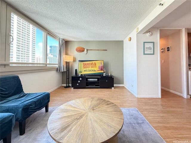 445 Seaside Ave Unit 1120, Honolulu, HI 96815 - living room featuring light wood finished floors, a textured ceiling, and baseboards