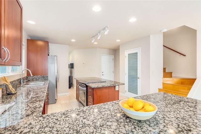 91-2106B Fort Weaver Rd Unit 15, Ewa Beach, HI 96706 - kitchen featuring appliances with stainless steel finishes, light stone countertops, brown cabinets, a kitchen island, and light tile patterned floors